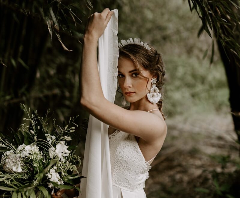 woman wearing white bridal gown across green forest