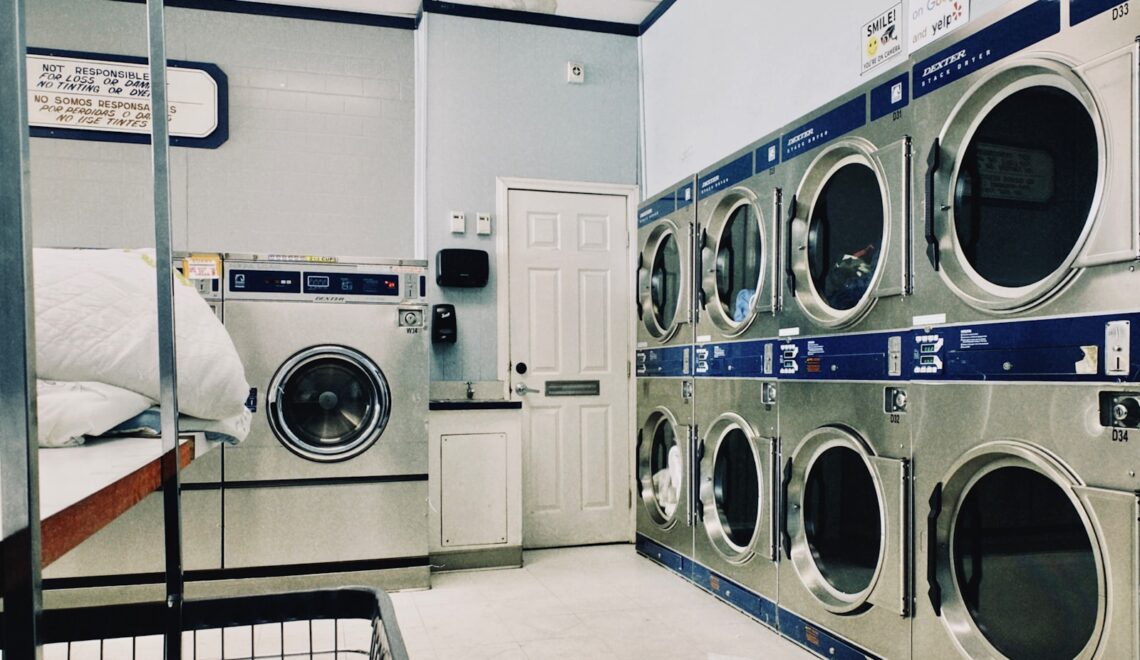 a row of washers and dryers in a laundry room
